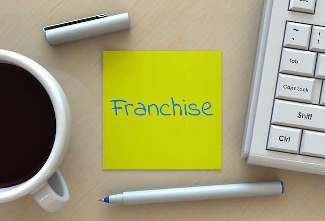 franchise, message on note paper, computer and coffee on table, 3D rendering